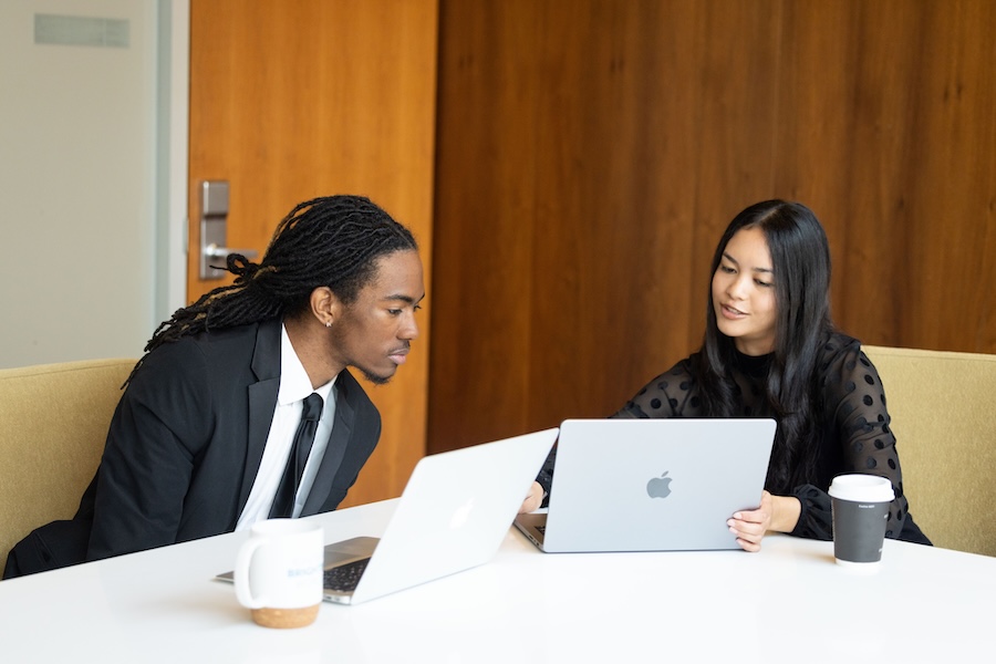 Students working on laptops in business clothes